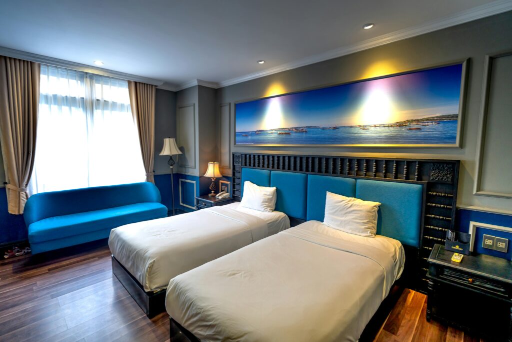 Luxurious hotel room features twin beds, modern decor, and ambient lighting.