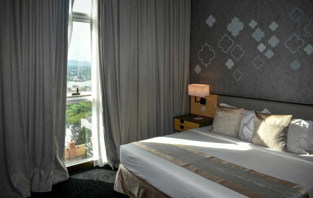 Cozy modern hotel room with large window and mountain view, perfect for travelers.